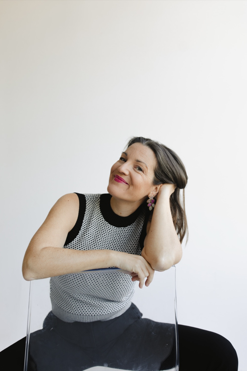 Megan Swan seated, resting her head on her hand, smiling